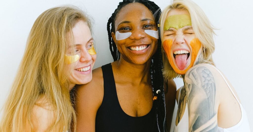 Three diverse women having fun with colorful skincare masks, embodying friendship and joy.